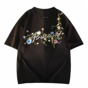 A black oversized tee featuring delicate, trailing floral embroidery or print.